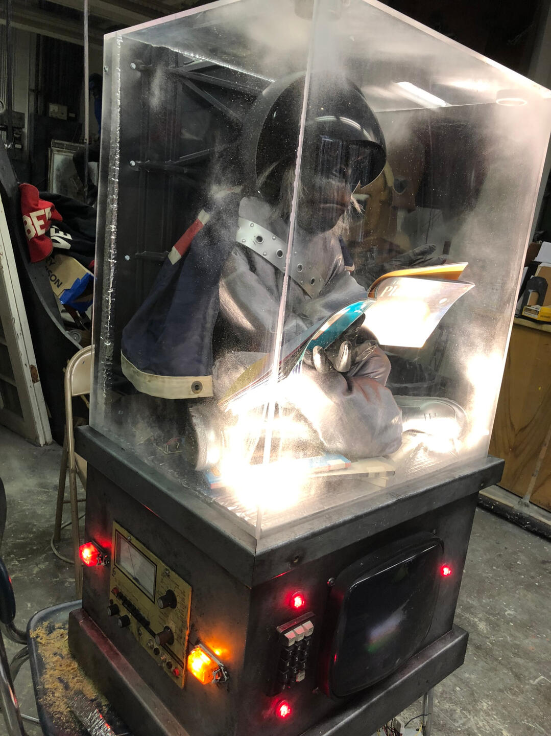 Fabricated frosted glass case with working television, lights, and buttons.