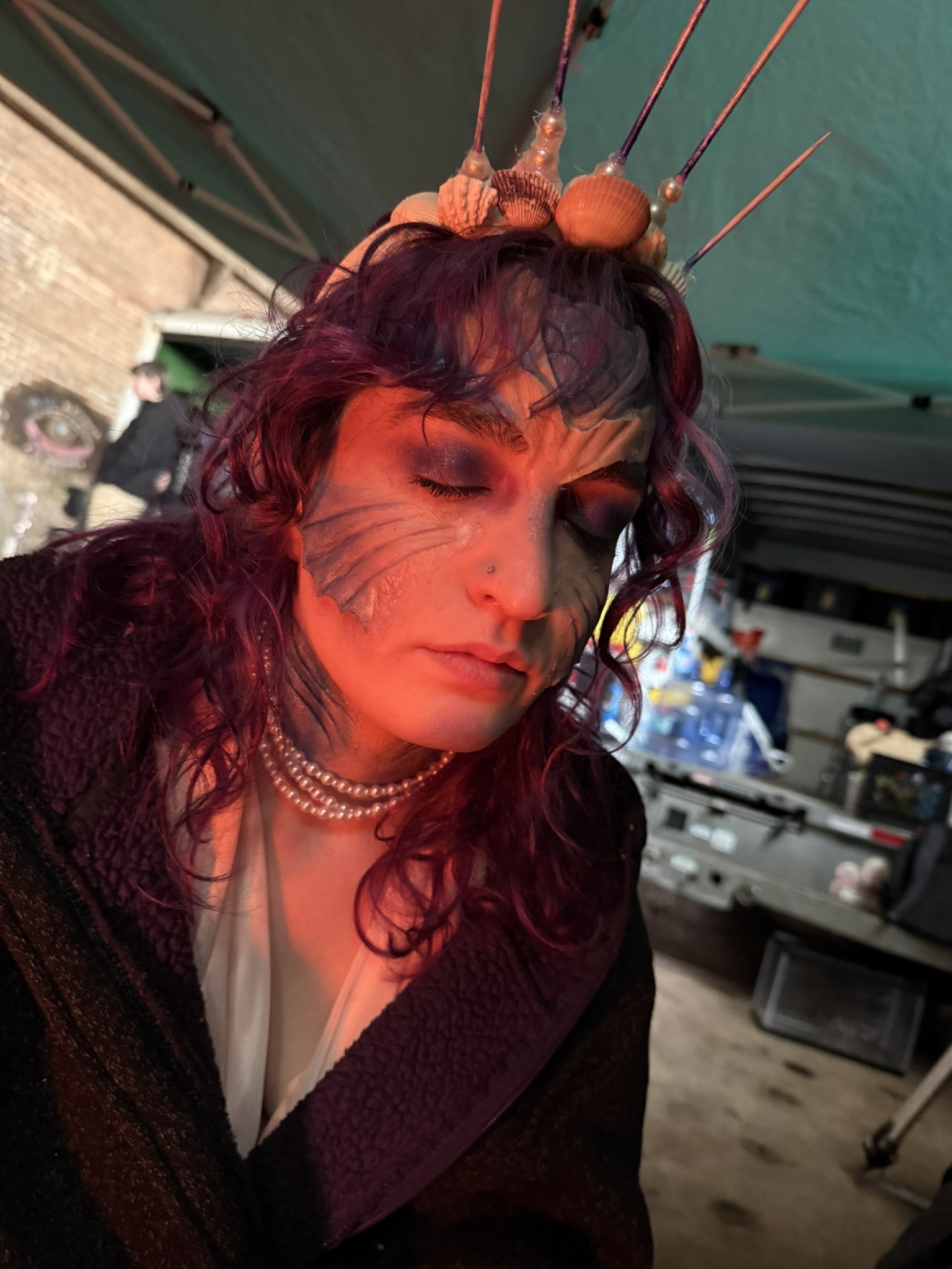 Makeup application of fishy prosthetics.